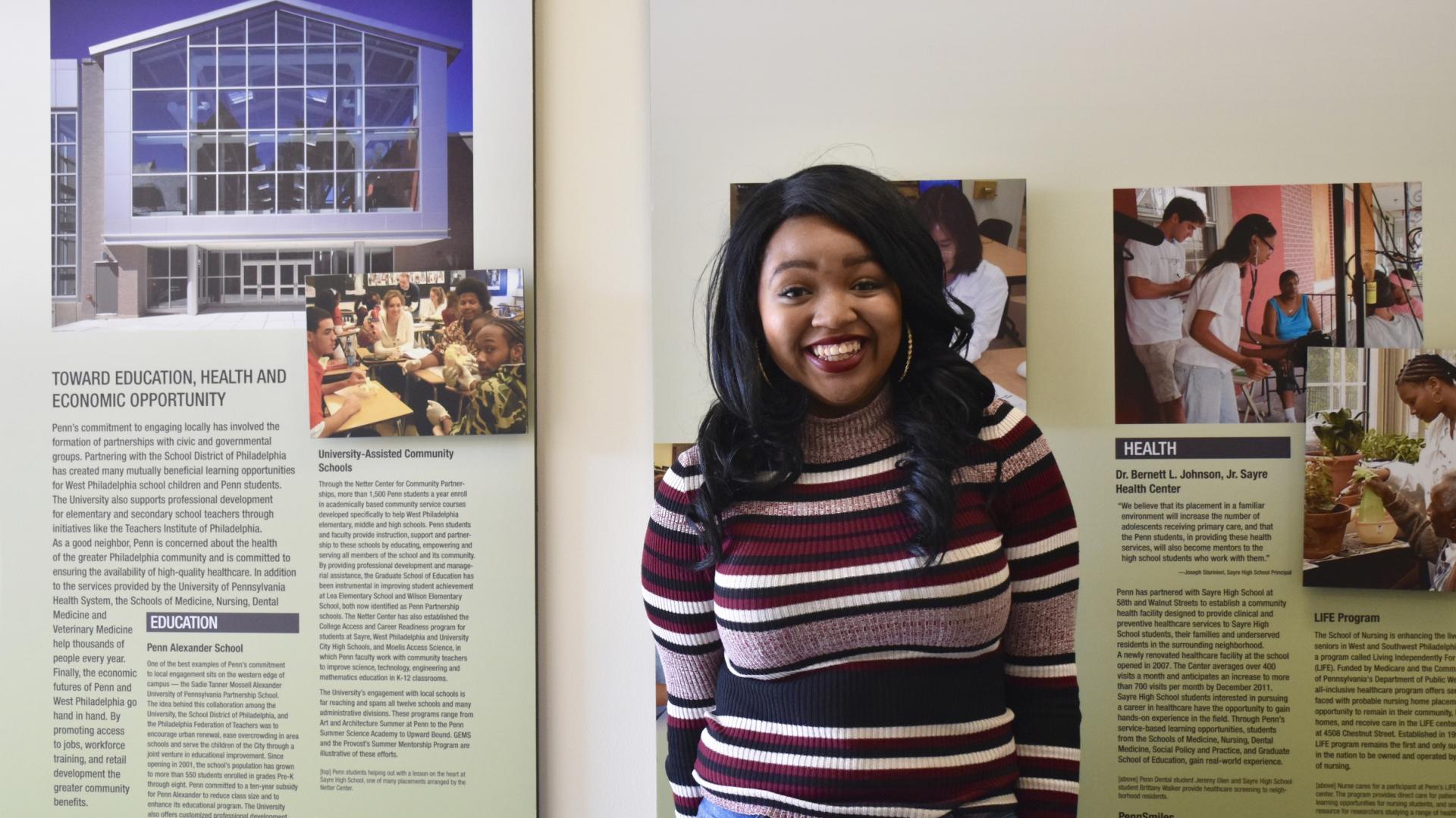 Student in front of signs in the Netter Center for Community Partnerships