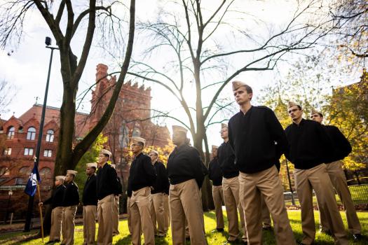 Penn veterans stand at attention outside of Fischer Fine Arts library